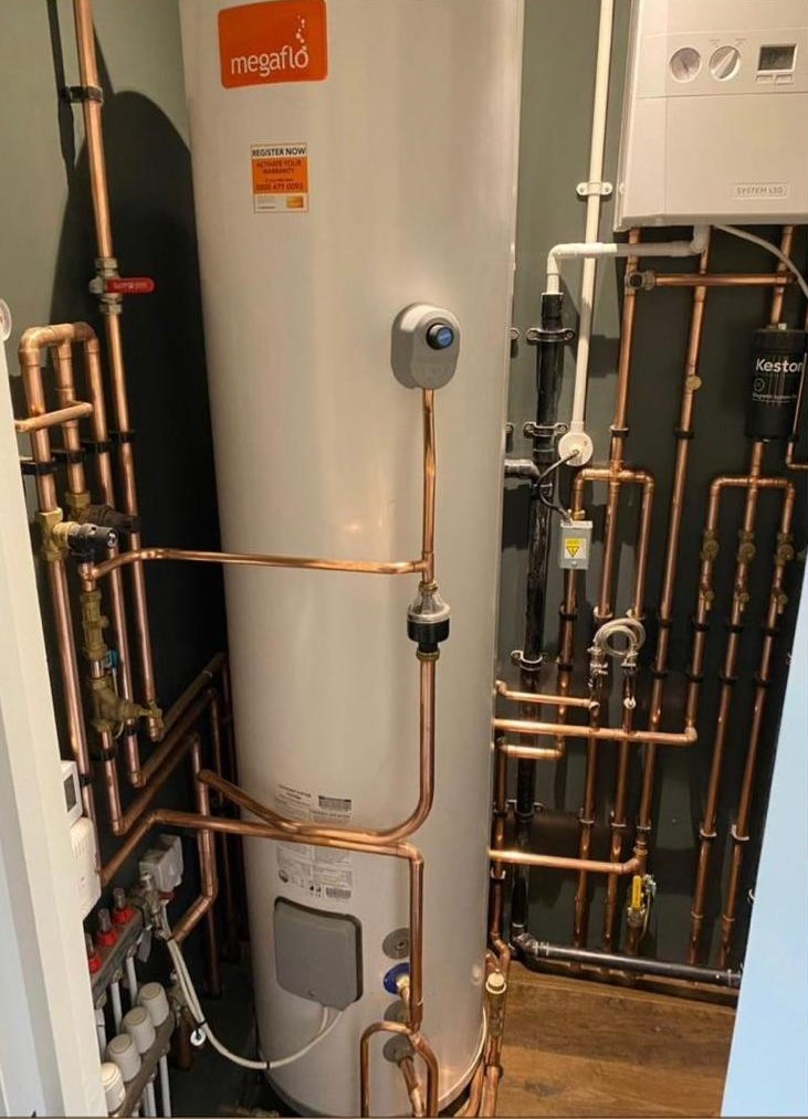 Engine Room with large megaflow air source heat pump with exposed copper pipes