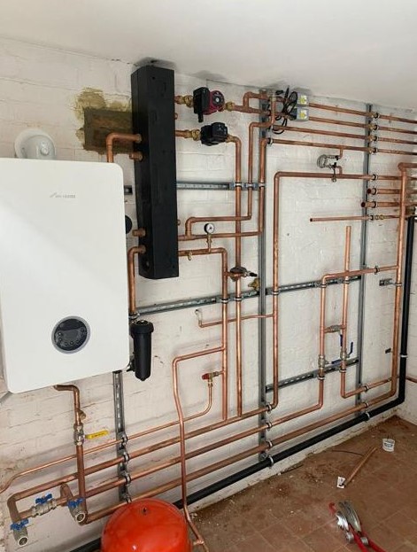 Plant Room with new boiler with intricate copper pipes on wall